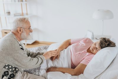 Man houdt hand vast van een zieke vrouw - Hospice-info