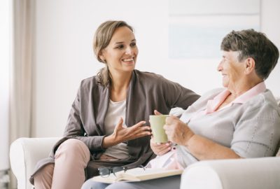 Een jonge vrouw aan het praten met een oudere vrouw - Hospice-info